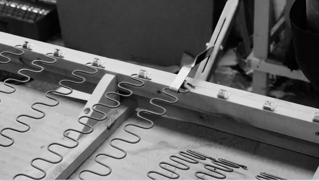 Close-up of a metal spring being installed on an Escapology Home handmade sofa.